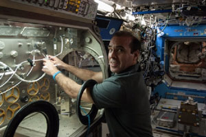 NASA astronaut Rick Mastracchio prepares to use Teledyne Brown’s system to decontaminate hardware used for life science experiments inside the Microgravity Science Glovebox on the ISS. Photo Credit: NASA. 